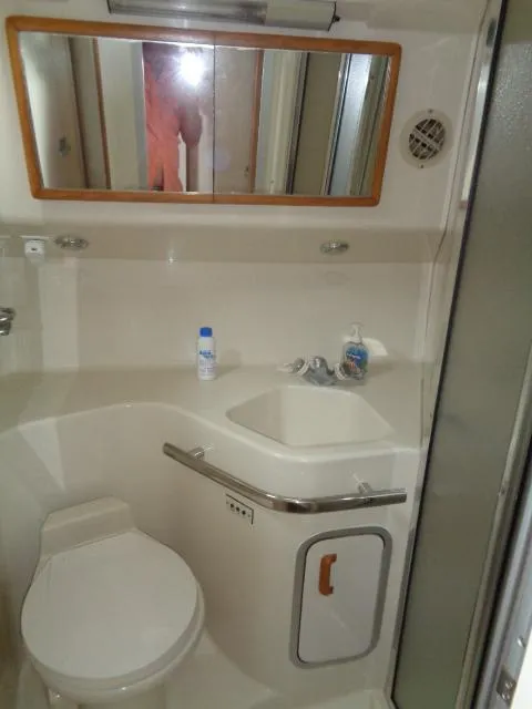 Slide: The Image of Bathroom in 1995 Sea Ray 400 Express Cruiser with sink, toilet, and mirror. - 10