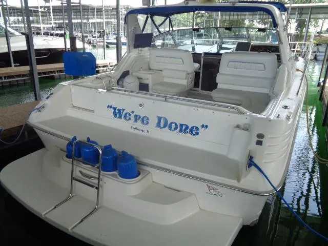 Slide: The Image of 1995 Sea Ray 400 Express Cruiser docked, rear view with We're Done name. - 2