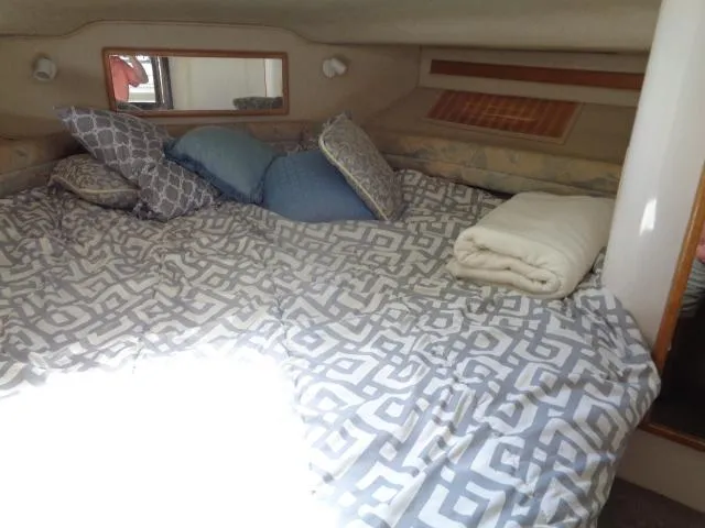 Slide: The Image of 1995 Sea Ray 400 Express Cruiser cozy cabin bed with pillows and blanket. - 8