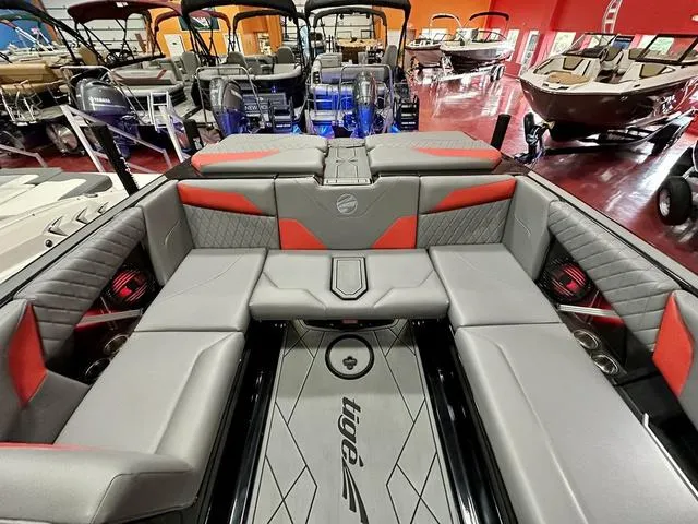 Slide: The Image of 2024 Tigé Z3 boat interior with gray and red seating in showroom. - 16