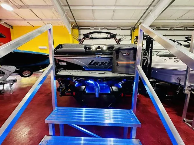 Slide: The Image of 2024 Tigé Z3 boat displayed in a showroom with blue LED lighting. - 5