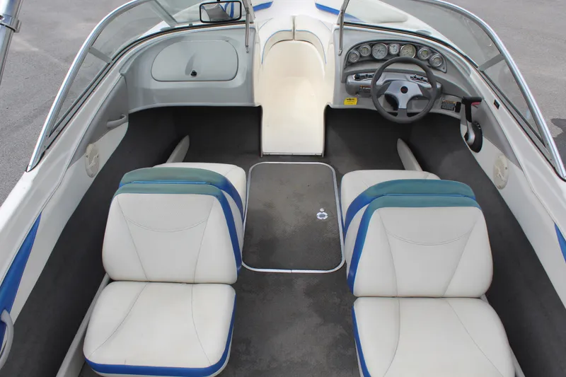 Slide: The Image of 2007 Bayliner 185 Bowrider interior with white and blue seating, dashboard, and steering wheel. - 12