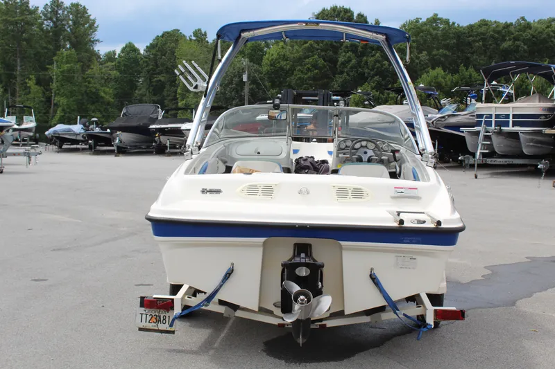 Slide: The Image of 2007 Bayliner 185 Bowrider boat on trailer, parked in marina with other boats. - 4