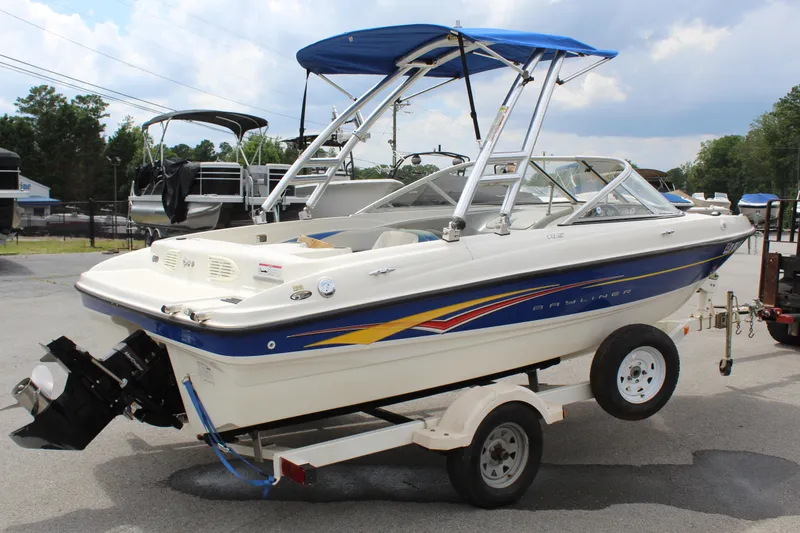 Slide: The Image of 2007 Bayliner 185 Bowrider on trailer, featuring blue and white design with canopy. - 6