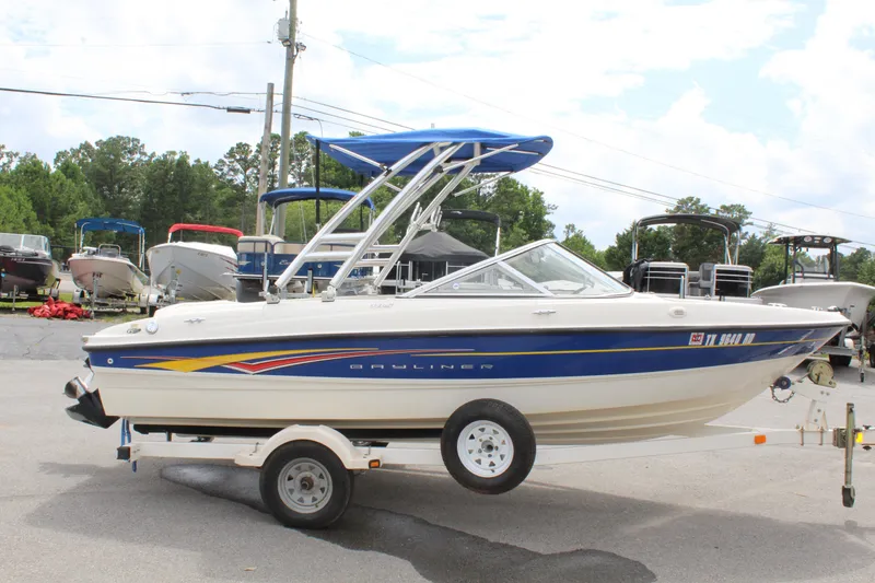 Slide: The Image of 2007 Bayliner 185 Bowrider on trailer, parked outdoors with other boats in background. - 8