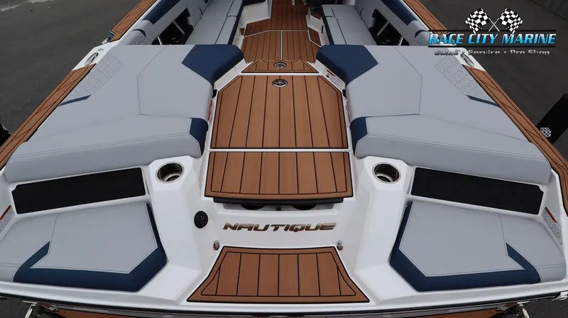 Slide: The Image of 2024 Nautique GS24 boat interior with teak flooring and cushioned seating. - 14