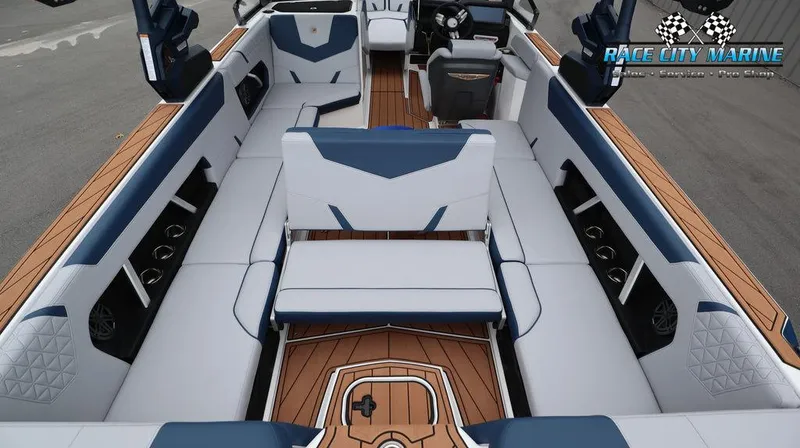 Slide: The Image of 2024 Nautique GS24 boat interior with white and blue seating, teak flooring, and Race City Marine logo. - 16