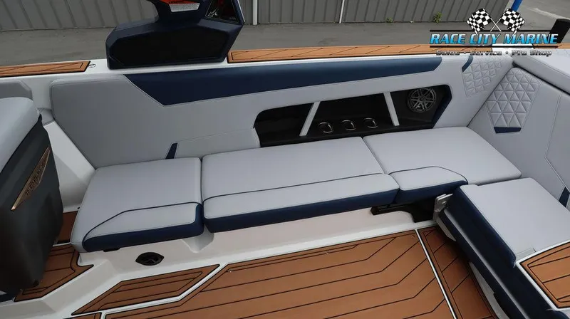 Slide: The Image of 2024 Nautique GS24 boat interior with cushioned seating and teak flooring. - 23