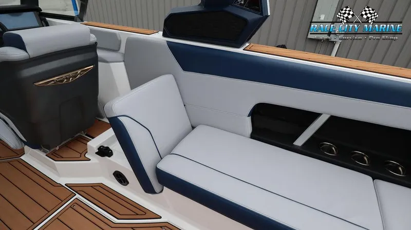 Slide: The Image of 2024 Nautique GS24 boat interior with blue and white seating, teak flooring, and Race City Marine logo. - 24