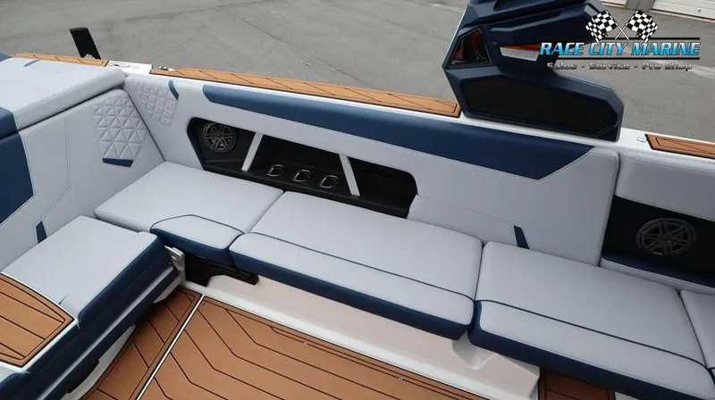 Slide: The Image of 2024 Nautique GS24 boat interior with blue and white seating, Race City Marine logo. - 26