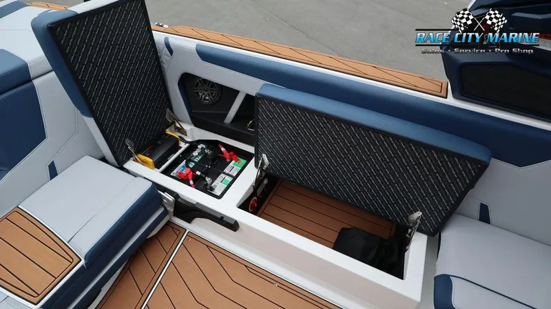 Slide: The Image of 2024 Nautique GS24 boat interior storage compartments open, showcasing battery and wiring. - 27
