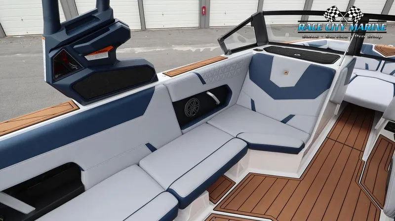 Slide: The Image of 2024 Nautique GS24 boat interior with blue and white seating, teak flooring, and Race City Marine logo. - 28