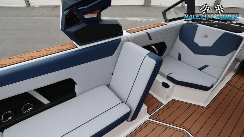 Slide: The Image of 2024 Nautique GS24 boat interior with blue and white seating, Race City Marine logo. - 29