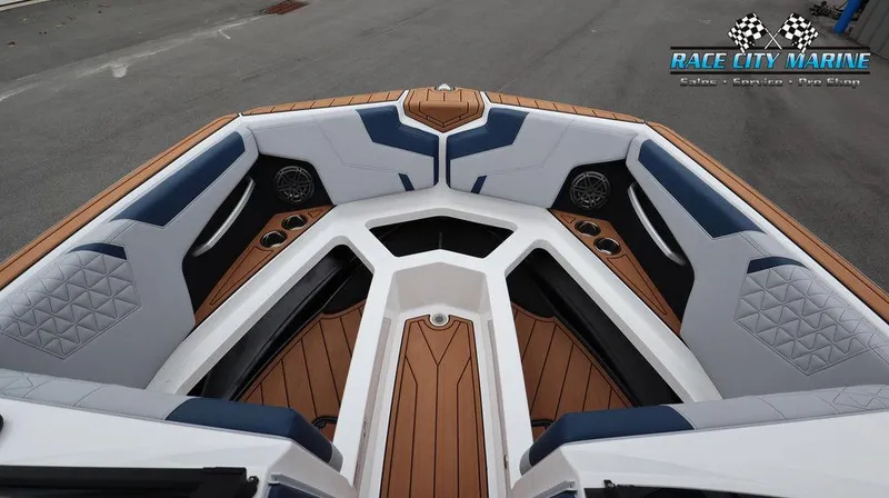 Slide: The Image of 2024 Nautique GS24 boat interior with teak flooring and cushioned seating. - 46