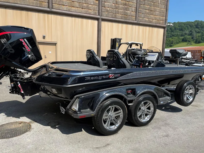 Slide: The Image of 2024 Ranger Z521R Ranger Cup Equipped boat with dual-axle trailer, parked outdoors. - 2