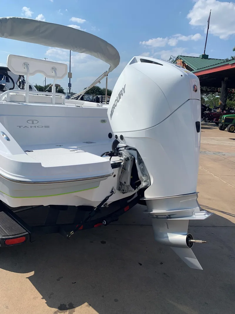 Slide: The Image of 2024 Tahoe 2150 CC boat with Mercury outboard motor, docked on a sunny day. - 3