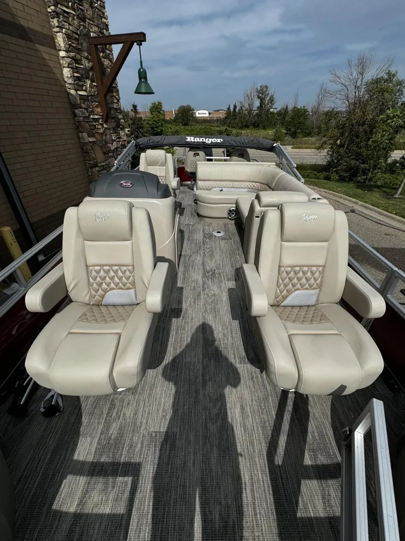 Slide: The Image of 2024 Ranger Reata 220F boat with beige seating and outdoor setting. - 2