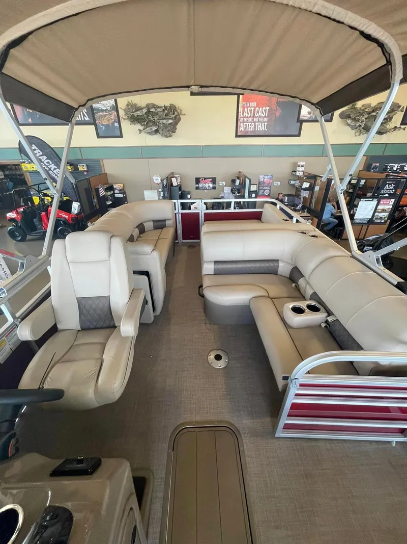 Slide: The Image of 2024 Ranger Reata 220F pontoon boat interior with beige seating and canopy. - 3
