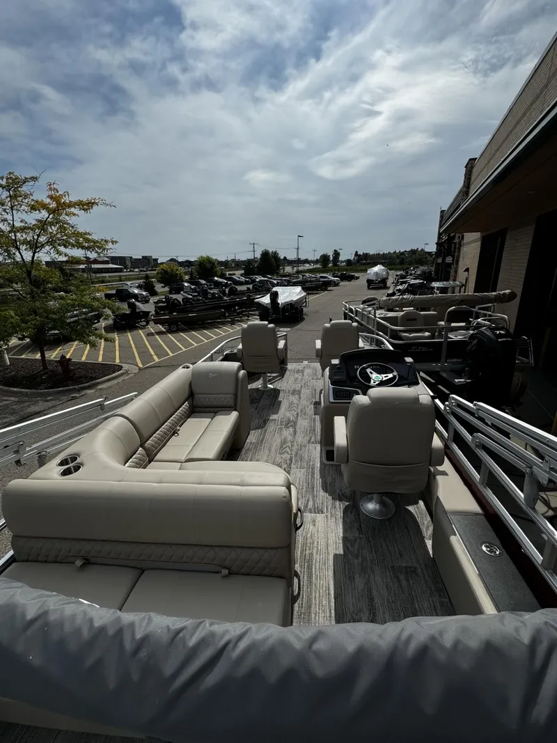 Slide: The Image of 2024 Ranger Reata 220F pontoon boat with beige seating and modern design. - 7