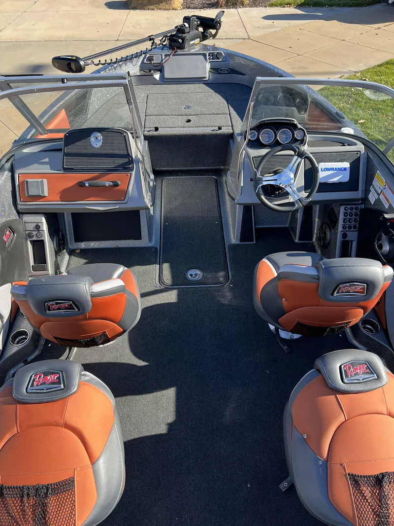 Slide: The Image of 2024 Ranger 1850MS boat interior with orange and gray seats, steering wheel, and dashboard. - 9