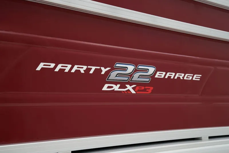Slide: The Image of 2024 Sun Tracker Party Barge 22 XP3 logo on red boat exterior. - 17