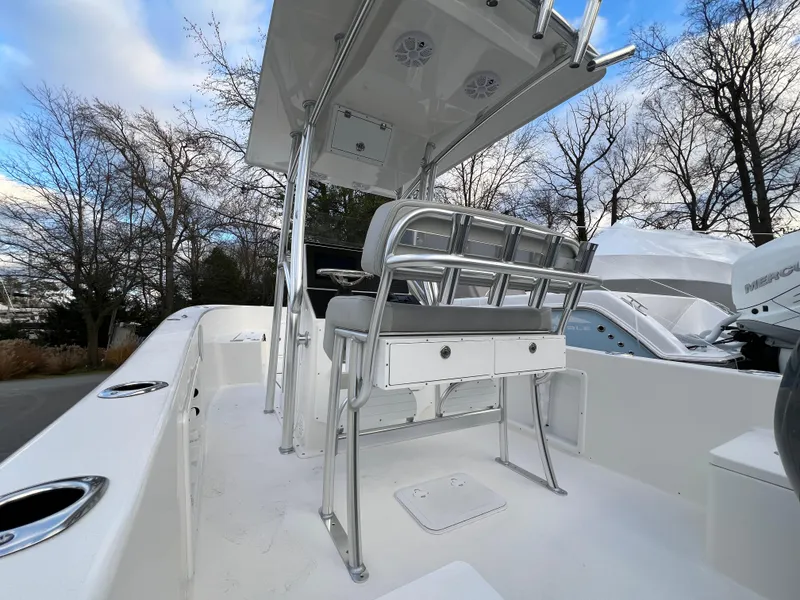 Slide: The Image of 2024 KenCraft 21 boat with seating and console, surrounded by trees and blue sky. - 10