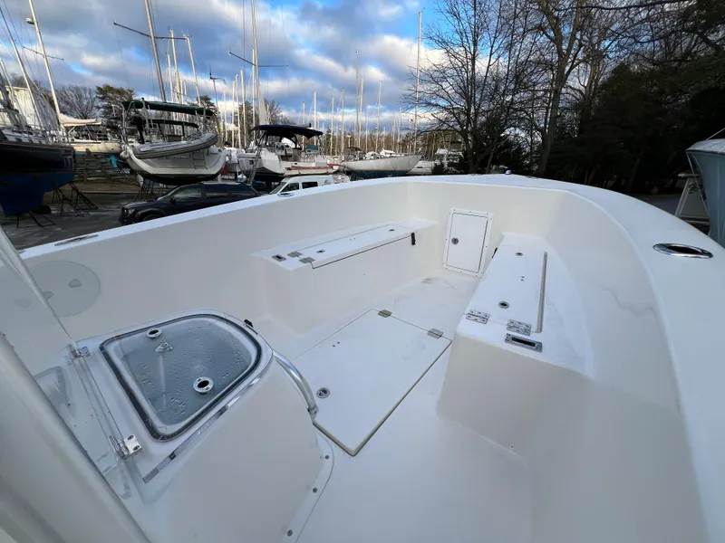 Slide: The Image of 2024 KenCraft 21 boat interior with storage compartments, docked among other boats. - 4
