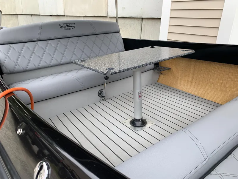 Slide: The Image of 2021 Vision Marine Technologies Quietude 156 boat interior with grey seating and table. - 5