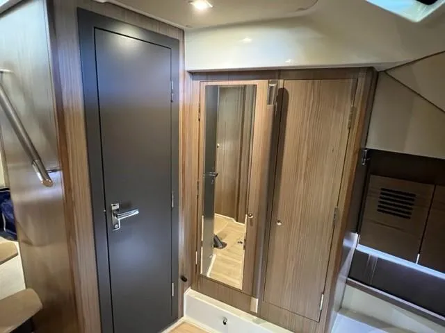 Slide: The Image of 2018 Chris-Craft Launch 38 interior with wooden cabinetry and mirrored closet. - 13