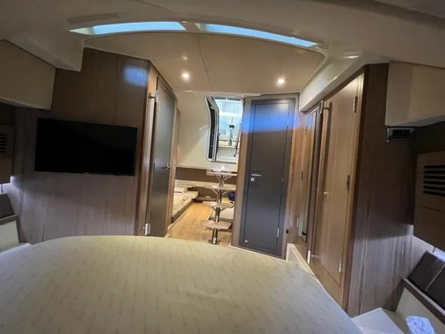 Slide: The Image of 2018 Chris-Craft Launch 38 interior cabin with modern wood finish and cozy seating area. - 16