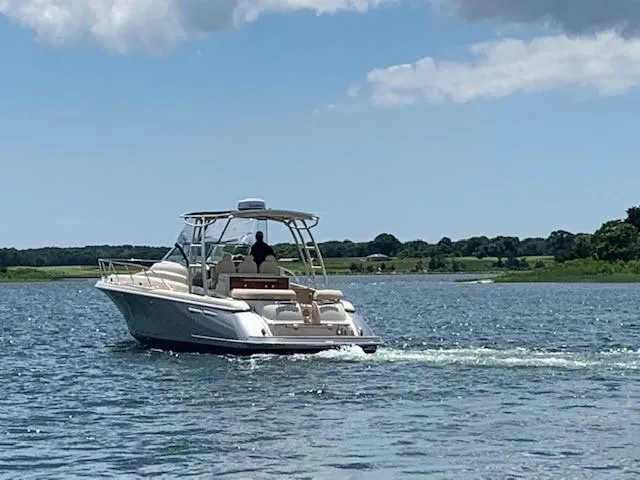Slide: The Image of 2018 Chris-Craft Launch 38 boat cruising on a serene lake under a blue sky. - 25