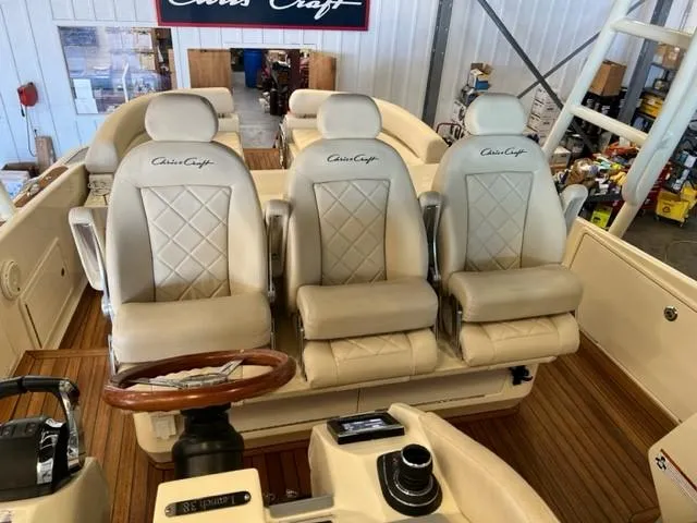 Slide: The Image of 2018 Chris-Craft Launch 38 boat interior with three luxury seats and wooden steering wheel. - 9