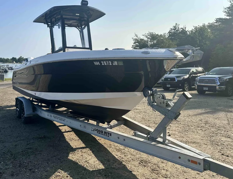 Slide: The Image of 2016 Robalo 2420 Center Console boat on a Load Rite trailer in a parking lot. - 0