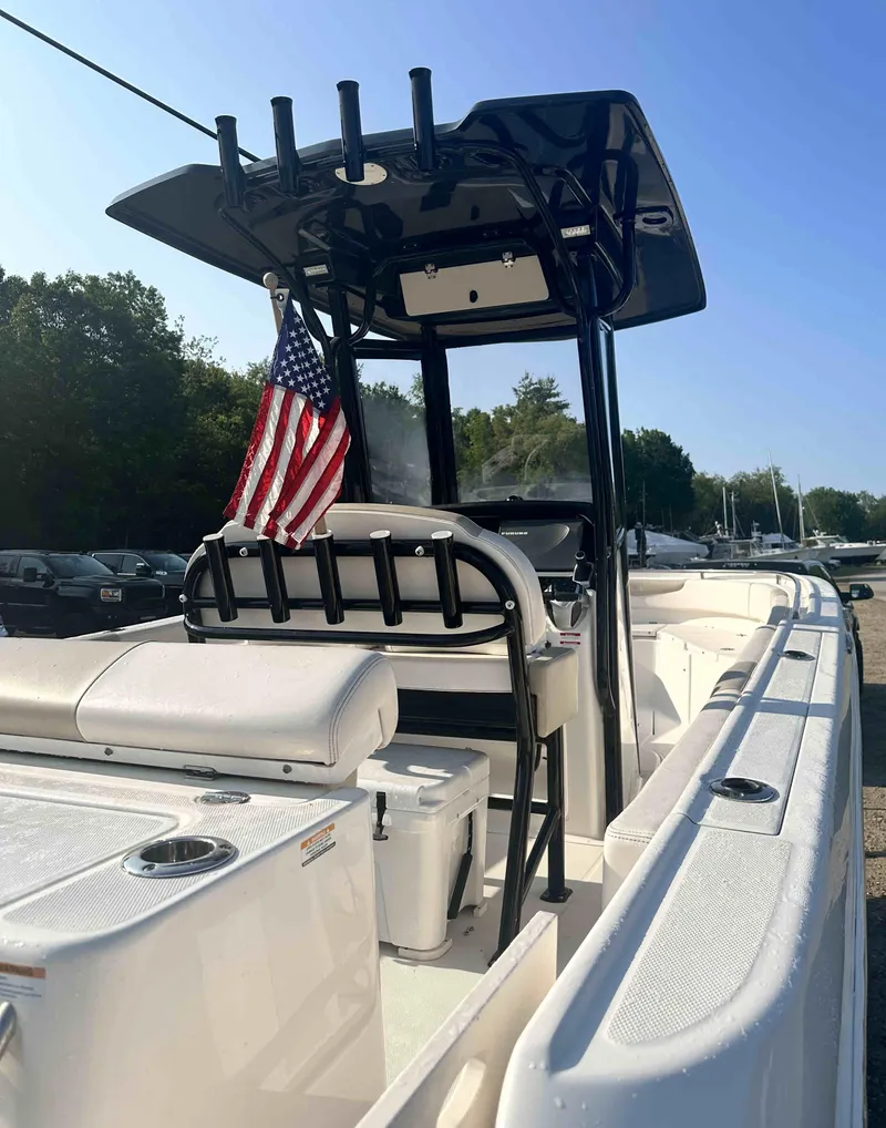 Slide: The Image of 2016 Robalo 2420 Center Console boat with American flag, docked. - 5