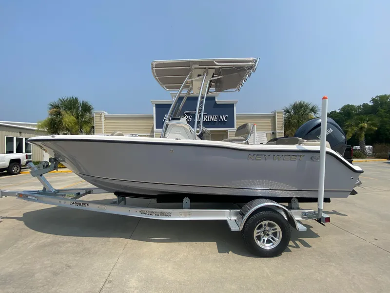 Slide: The Image of 2024 Key West 203 FS boat on trailer, displayed outdoors at a marine dealership. - 0
