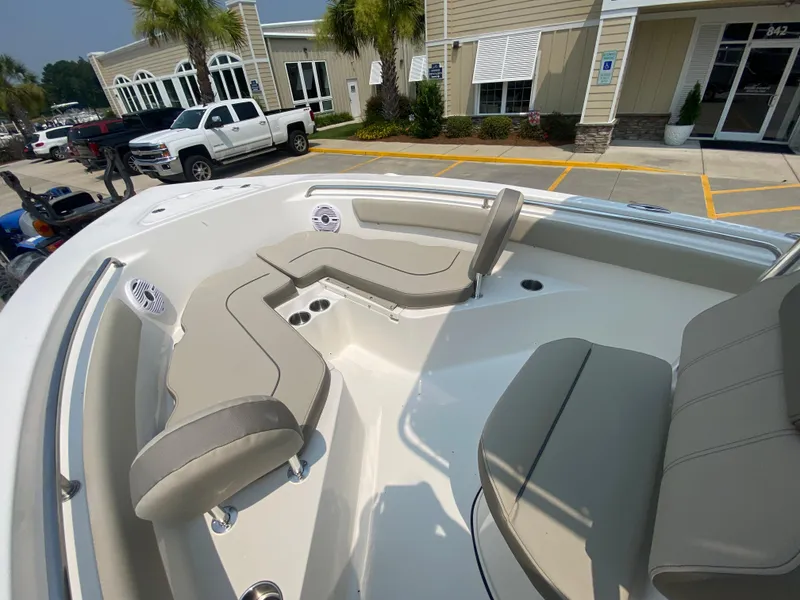 Slide: The Image of 2024 Key West 203 FS boat with beige seating, parked outside a dealership. - 18