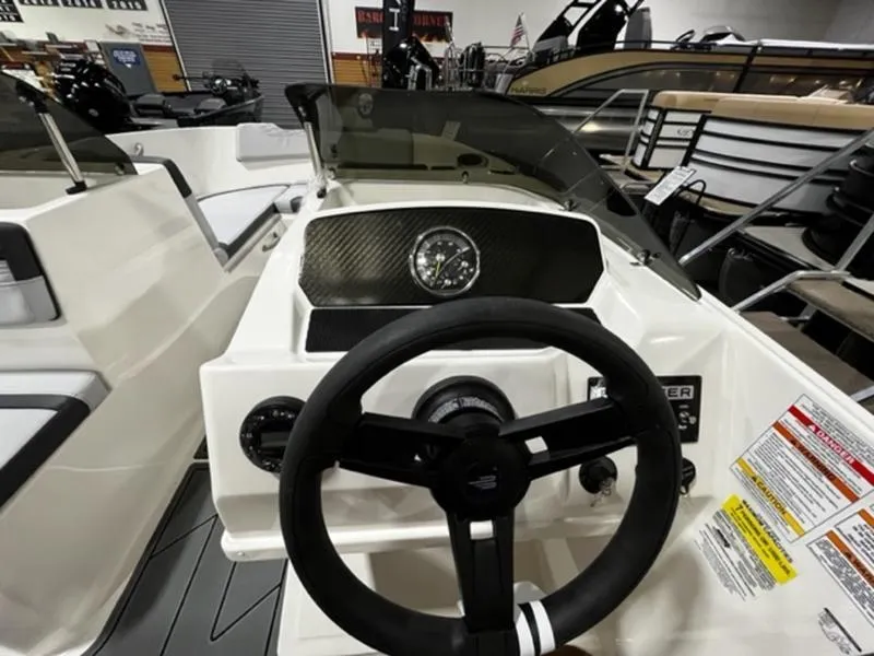 Slide: The Image of 2024 Bayliner Element M17 boat dashboard with steering wheel and instrument panel. - 7