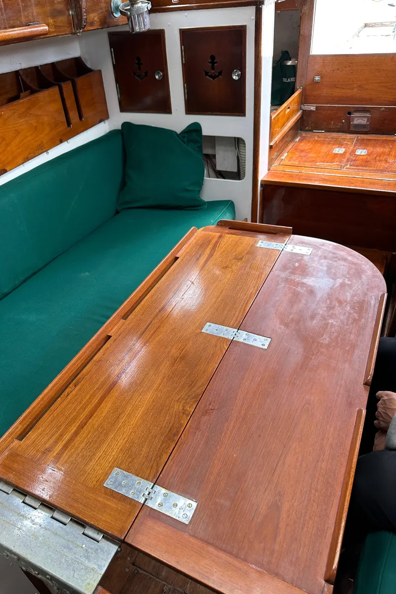 Slide: The Image of Interior of 1964 Cheoy Lee Lion Class Sloop with wooden table and green seating. - 18
