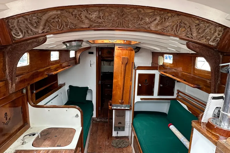 Slide: The Image of 1964 Cheoy Lee Lion Class Sloop interior with wood detailing and green cushions. - 25