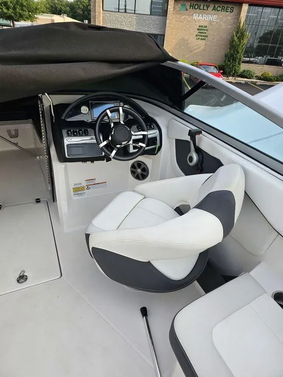 Slide: The Image of 2017 Regal 23 OBX boat interior with steering wheel and captain's chair. - 2