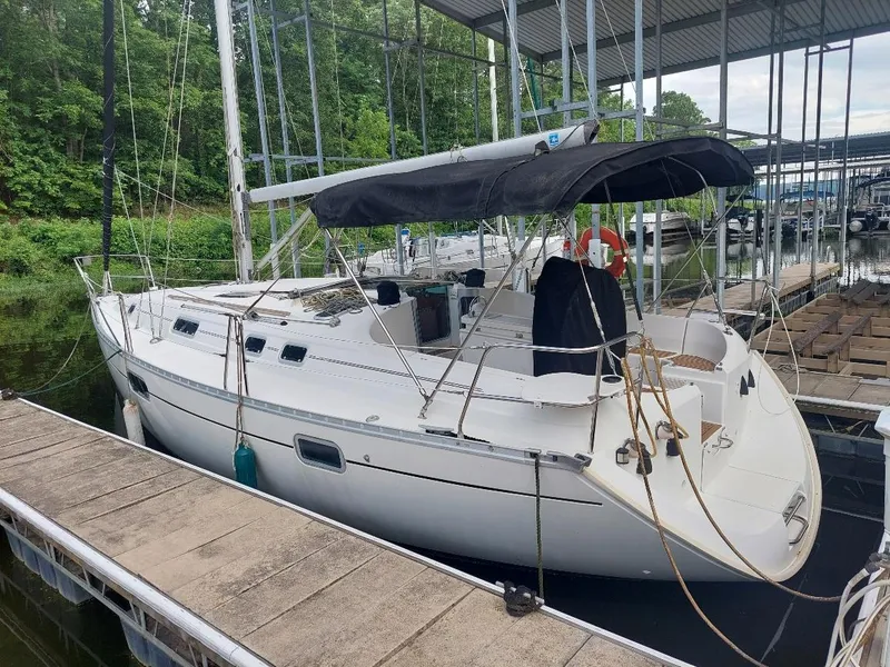 The Image of 1995 Beneteau Oceanis 351 sailboat docked at marina, featuring a sleek white design. - 2