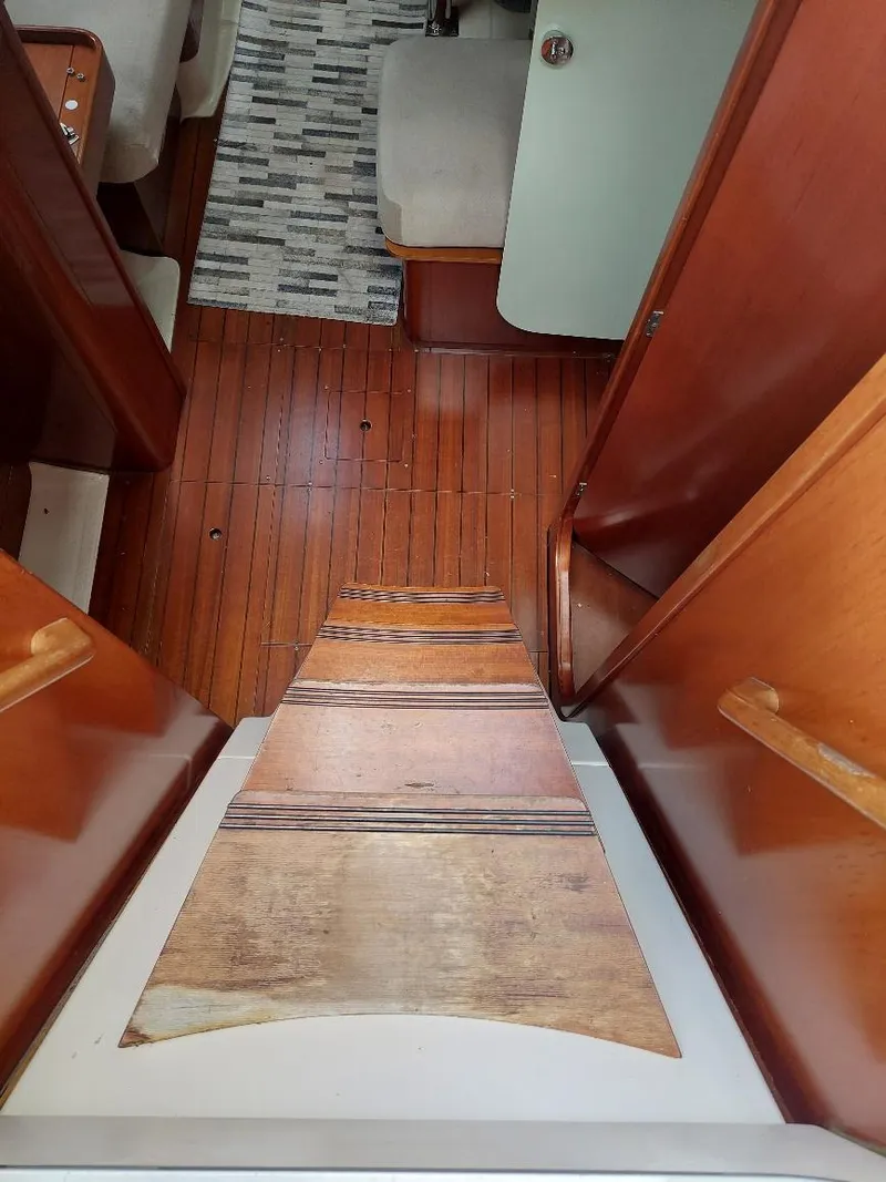 Slide: The Image of Interior view of 1995 Beneteau Oceanis 351 sailboat with wooden flooring and seating area. - 20
