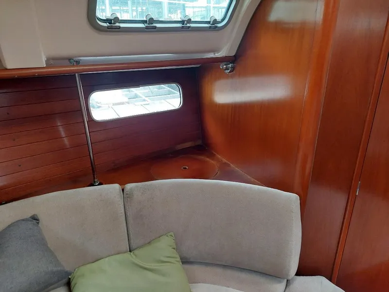 Slide: The Image of Interior of 1995 Beneteau Oceanis 351 sailboat with wooden paneling and cushioned seating. - 49