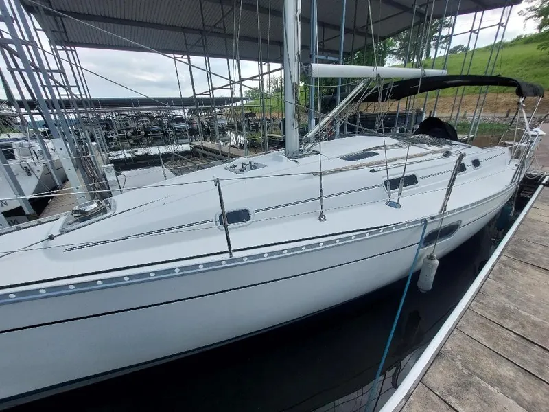 Slide: The Image of 1995 Beneteau Oceanis 351 sailboat docked at a marina under a covered structure. - 7