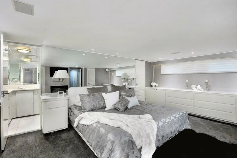 Slide: The Image of Luxurious bedroom in a 1983 Broward 108 Cockpit Motor Yacht with modern decor. - 10