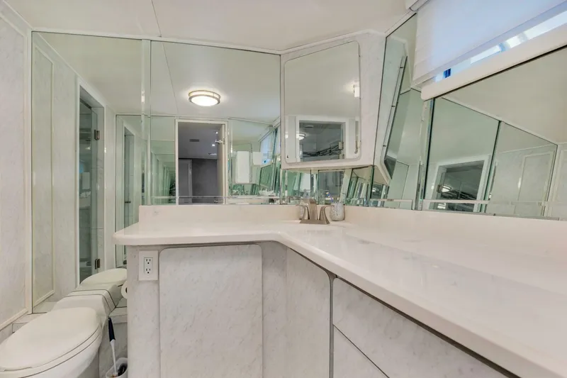 Slide: The Image of Luxurious bathroom in 1983 Broward 108 Cockpit Motor Yacht with mirrored walls and modern fixtures. - 14
