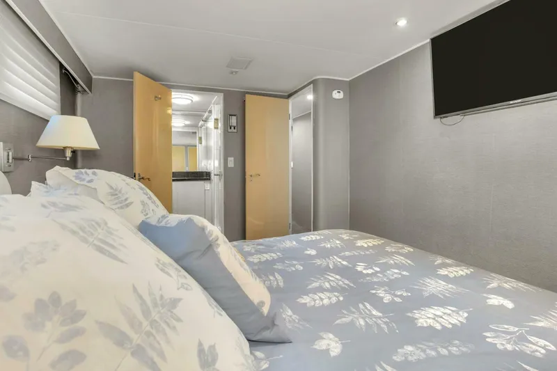 Slide: The Image of Luxurious bedroom in a 1983 Broward 108 Cockpit Motor Yacht with modern decor. - 16