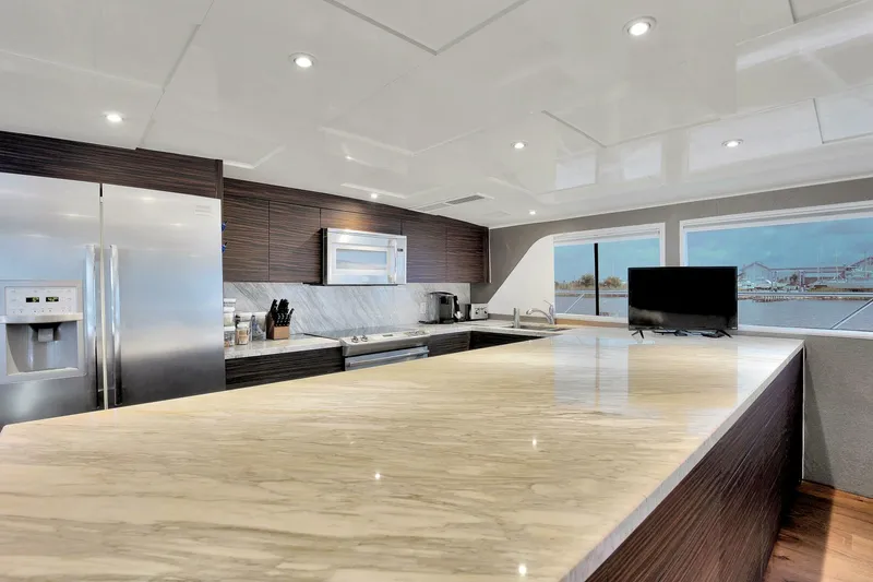 Slide: The Image of Modern kitchen interior on 1983 Broward 108 Cockpit Motor Yacht with marble countertops. - 19