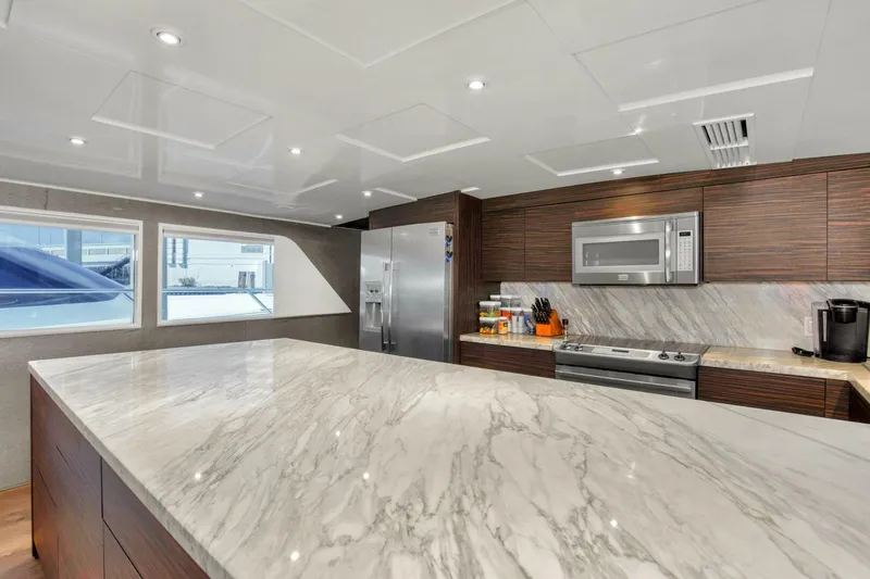 Slide: The Image of Modern kitchen interior on 1983 Broward 108 Cockpit Motor Yacht with marble countertops. - 23