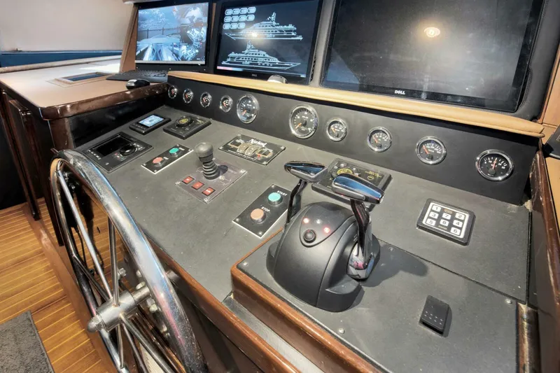 Slide: The Image of 1983 Broward 108 Cockpit Motor Yacht helm station with navigation controls and displays. - 33